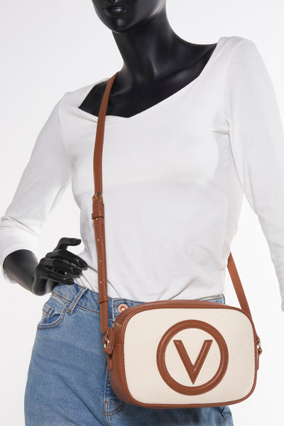 Beige schoudertas van VALENTINO BAGS met een 'V'-logo aan de voorkant, gedragen door een paspop.