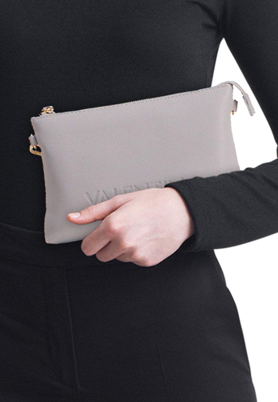 Sac à bandoulière gris par VALENTINO BAGS, porté avec une chemise et un pantalon noirs.