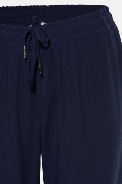 Pantalon bleu marine de Zabaione avec cordon de serrage à la taille élastiquée, coupe droite et texture plissée.