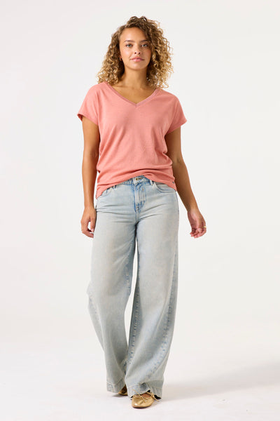 T-shirt pêche à manches courtes de GARCIA, porté avec un jean large et des ballerines dorées.

