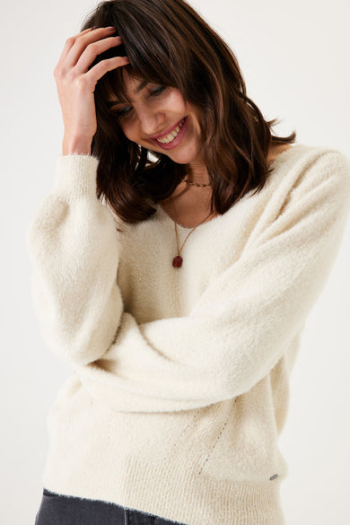 Pull à col en V écru de GARCIA, avec manches bouffantes et un collier à pendentif.