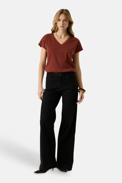 Brick red short-sleeve V-neck T-shirt with textured knit, worn with black wide-leg jeans and layered gold necklace, front view