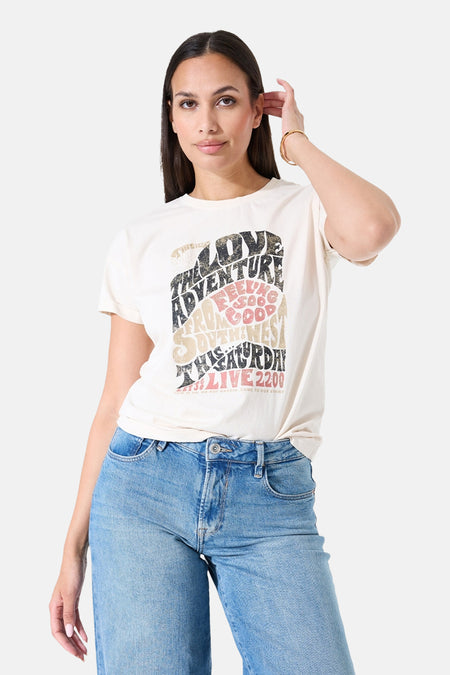 T-shirt à manches courtes écru de GARCIA, orné d'un imprimé graphique vintage et porté avec un jean bleu.
