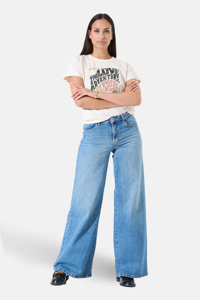 T-shirt à manches courtes écru de GARCIA, avec un imprimé graphique devant, porté avec un jean taille haute et des chaussures noires.