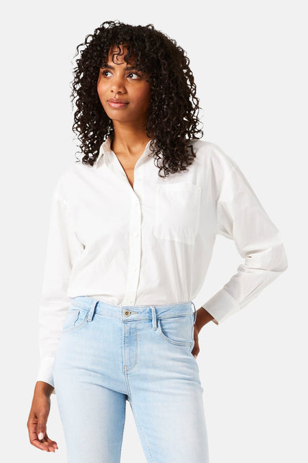 Chemisier blanc à manches longues par GARCIA, porté avec un jean taille haute bleu clair.