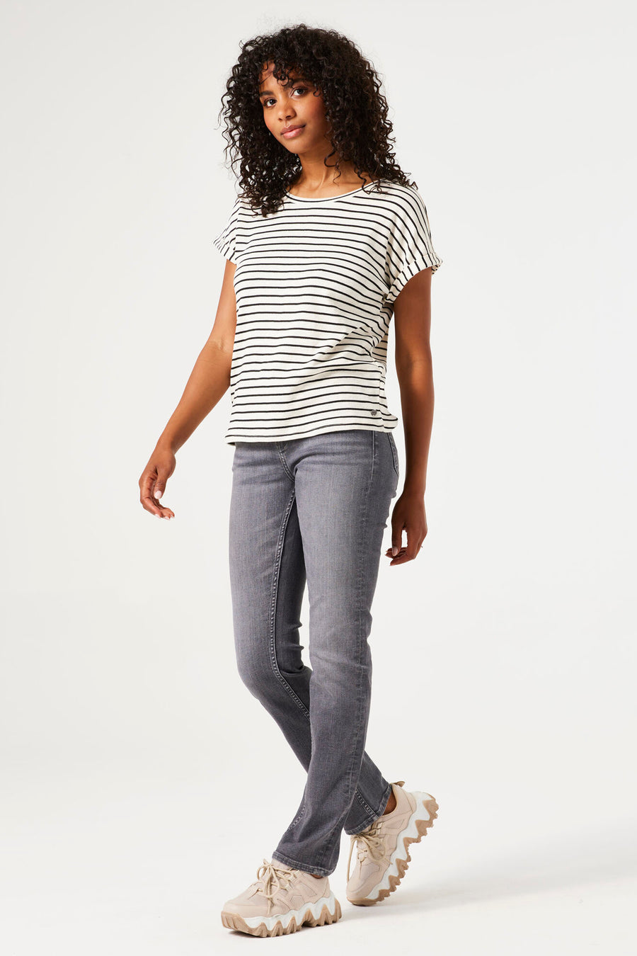 Ecru T-shirt met zwarte strepen van GARCIA, gedragen met een grijze jeans en beige sneakers met dikke zool.