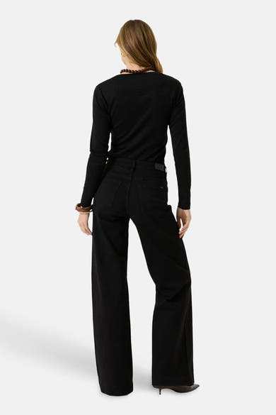 Black long-sleeve t-shirt with ribbed texture, back view, worn with black wide-leg pants and beaded necklace