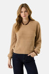 Beige fuzzy crewneck sweater with ribbed cuffs and hem, worn with dark jeans and beaded necklace, front view
