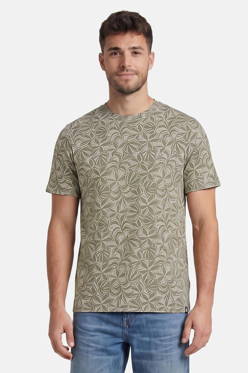 Multicolored short-sleeve t-shirt with leaf pattern, worn by model in front view, paired with blue jeans