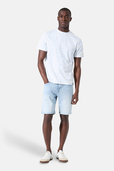 T-shirt blanc à motifs bleus de GARCIA, porté avec un short en jean et des baskets blanches.