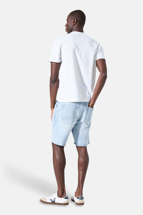 T-shirt blanc à manches courtes de GARCIA, avec motif imprimé clair sur l'ensemble, porté avec un short en jean.