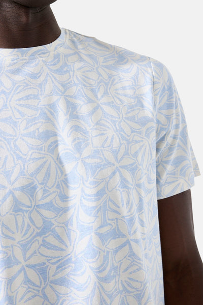 T-shirt blanc à motif floral, de GARCIA, porté par un homme au teint foncé, sur fond uni.
