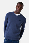 Blauwe V-hals trui van GARCIA, gedragen over een wit T-shirt, met een klein logo op de borst en een donkerblauwe jeans.