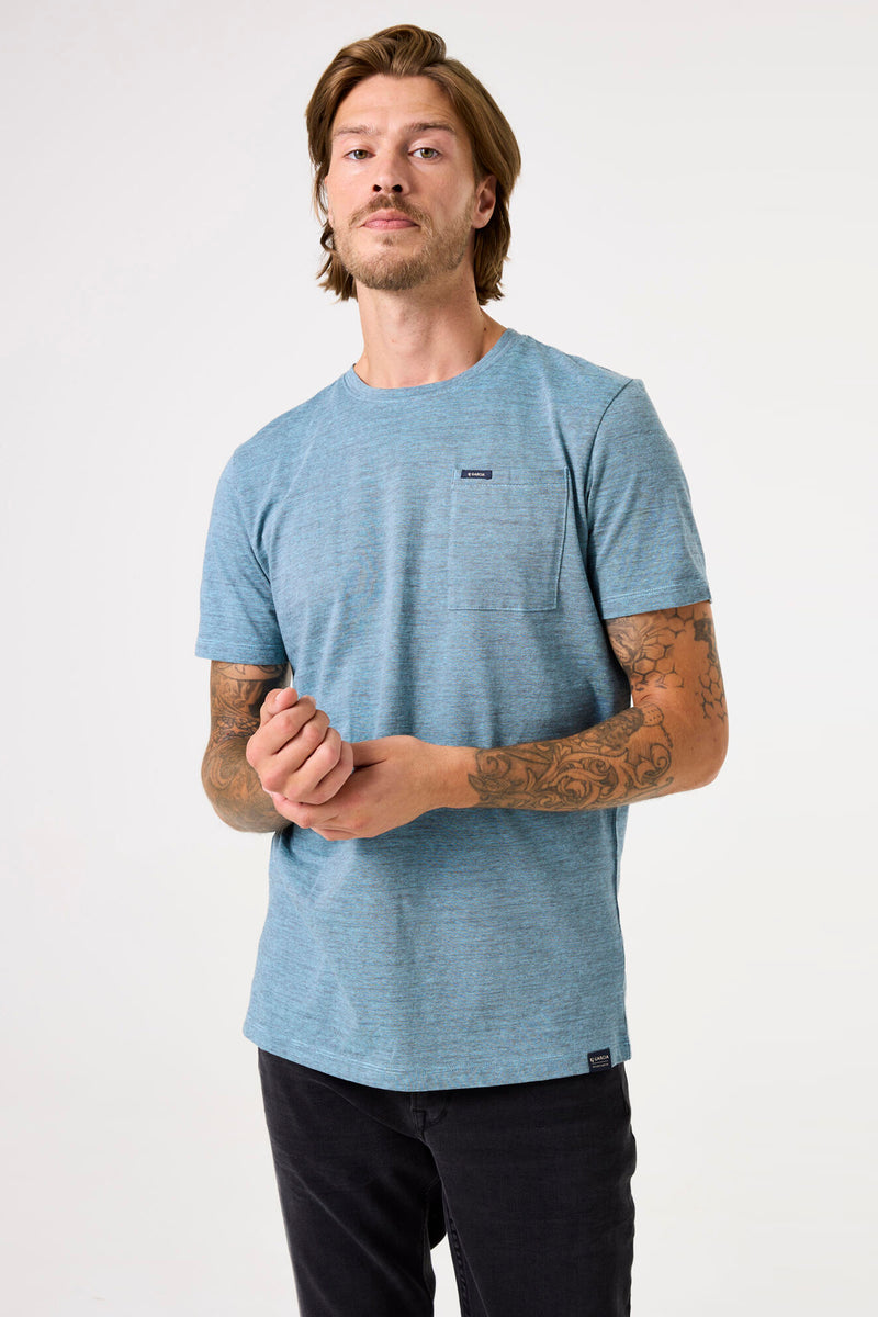 T-shirt turquoise à manches courtes de GARCIA, avec poche poitrine et étiquette logo en bas, porté avec un pantalon noir.