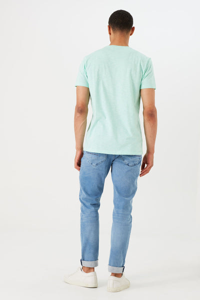 T-shirt à manches courtes turquoise de GARCIA, vu de dos, porté avec jean et chaussures blanches.