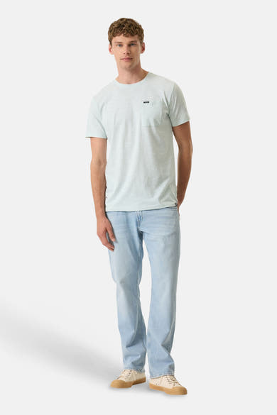 T-shirt vert clair à poche, par GARCIA, porté avec un jean délavé et des baskets beiges à semelle marron.