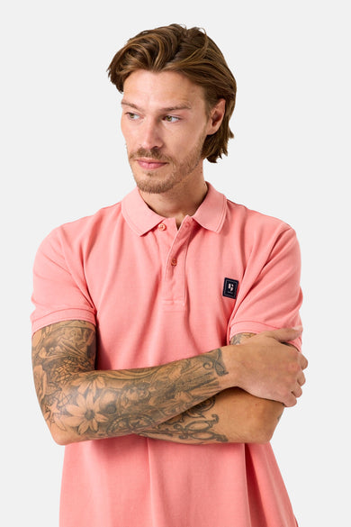 Polo rose à manches courtes de GARCIA, porté par un homme tatoué regardant sur le côté.