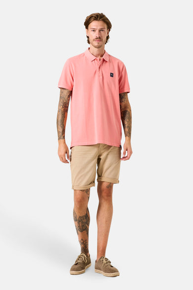 Polo à manches courtes rose de GARCIA, porté avec un short beige et des chaussures décontractées.