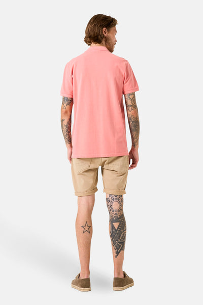 Polo à manches courtes rose de GARCIA, porté avec un short kaki et des chaussures en daim, vue de dos.