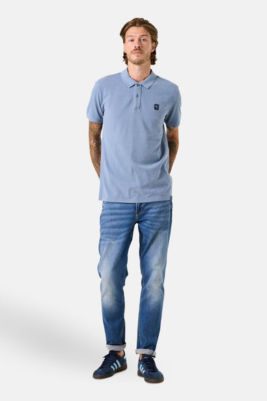 Polo bleu à manches courtes de GARCIA, porté avec un jean et des baskets bleues.