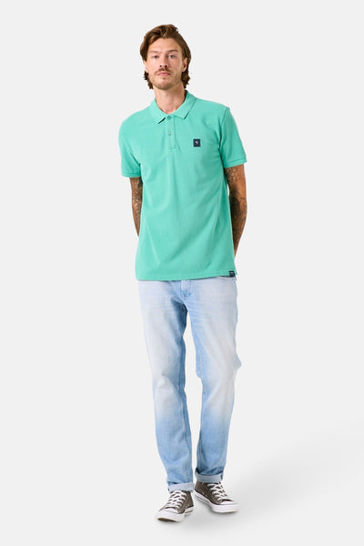 Polo à manches courtes vert de GARCIA, porté avec un jean délavé et des baskets en toile.