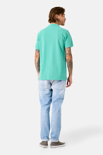 Polo à manches courtes vert de GARCIA, vu de dos, porté avec un jean clair et des baskets.