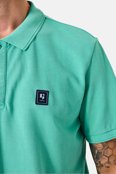 Polo à manches courtes vert de Garcia, avec logo carré sur la poitrine et motif piqué visible.

