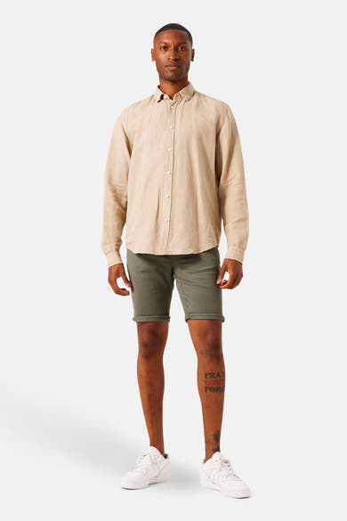Beige overhemd met lange mouwen van GARCIA, gedragen met een olijfgroene korte broek en witte sneakers.