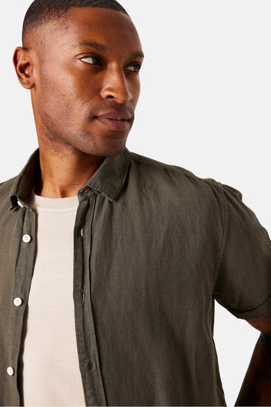Kaki overhemd met korte mouwen van GARCIA, gedragen open over een lichtbeige T-shirt.
