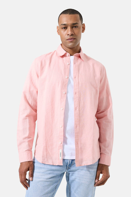 Chemise rose à manches longues de GARCIA, en tissu léger, portée ouverte sur un t-shirt blanc et un jean clair.