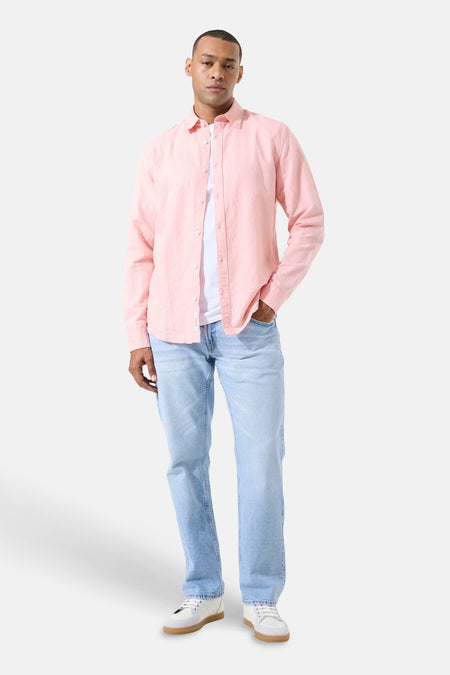 Chemise rose à manches longues de GARCIA en lin texturé, portée avec un t-shirt blanc, un jean clair et des baskets.