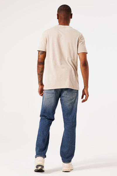 Beige T-shirt met korte mouwen van GARCIA, gedragen met een blauwe spijkerbroek en sneakers, achtergezicht.