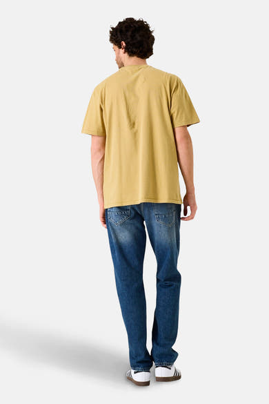 T-shirt à manches courtes jaune de GARCIA, porté avec un jean bleu et des baskets blanches à rayures noires.