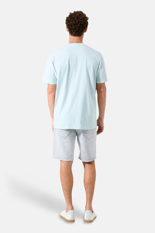 T-shirt vert clair de GARCIA, vu de dos, porté avec un short en jean et des chaussures blanches.