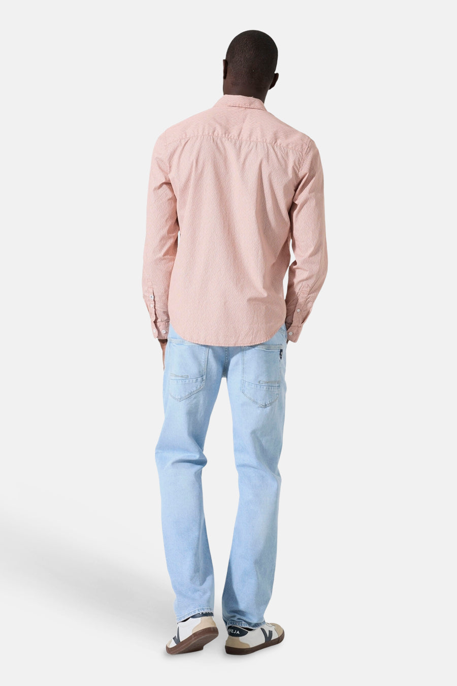 Chemise à manches longues orange à motifs, par GARCIA, portée avec un jean bleu clair et des baskets.
