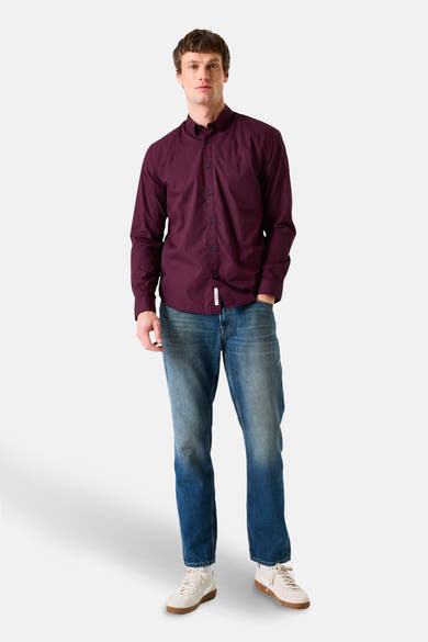 Bordeaux overhemd met lange mouwen van GARCIA, gedragen met een blauwe jeans en crèmekleurige sneakers.