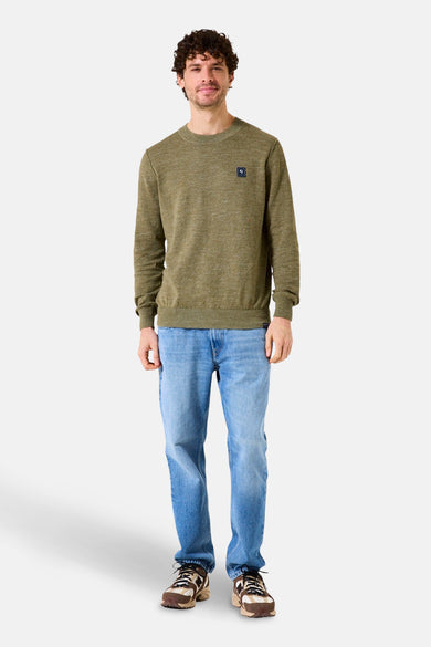 Pull à col rond kaki de GARCIA, porté avec un jean bleu et des baskets marron.