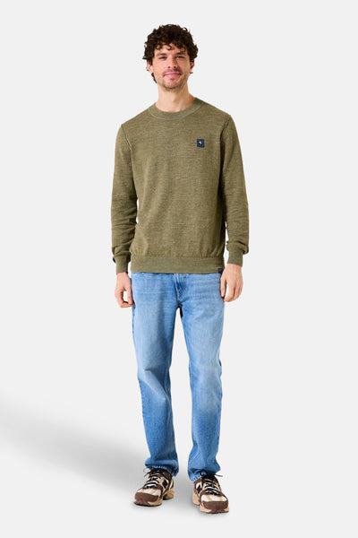 Pull à col rond kaki de GARCIA, porté avec un jean bleu et des baskets marron.