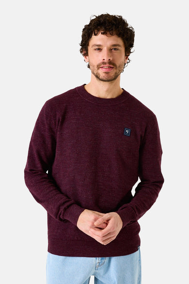 Pull à col rond bordeaux de GARCIA, avec un petit logo sur la poitrine, porté avec un jean clair.
