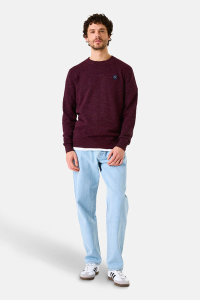 Pull à col rond bordeaux de GARCIA, porté avec un jean bleu clair et des baskets blanches.