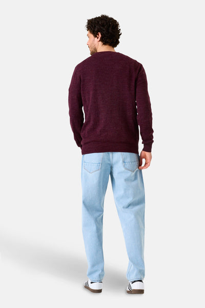 Pull à col rond bordeaux de GARCIA, avec un pantalon décontracté bleu clair et des chaussures de sport blanches.