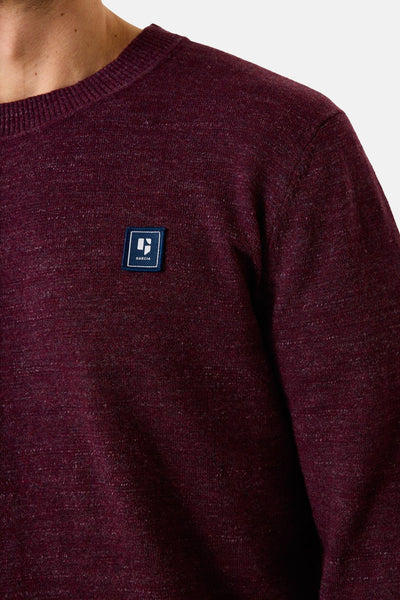 Pull à col rond bordeaux de GARCIA, en tricot texturé avec un écusson sur la poitrine.
