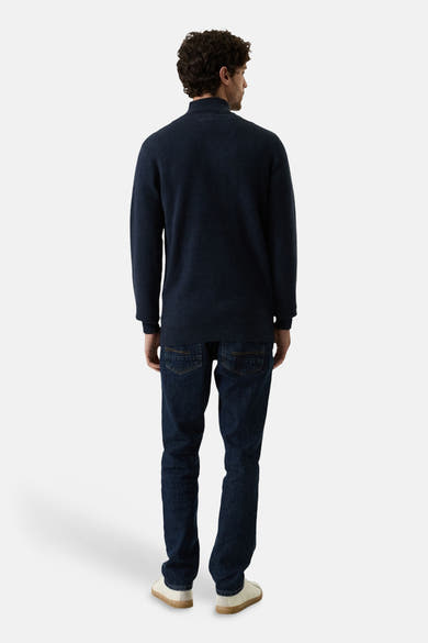 Navy blue turtleneck sweater back view, soft knit texture, worn with dark jeans and white sneakers
