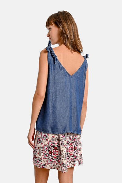 Molly Bracken blauw denim hemdje met strikbandjes, gedragen met een rok met patroon.