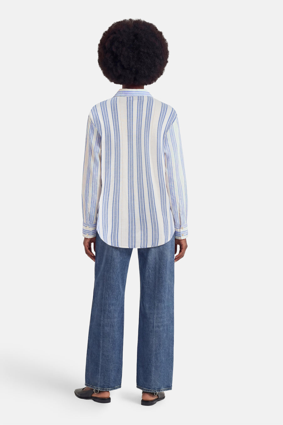 Robe à manches courtes multicolore de Molly Bracken. Mannequin de dos en chemise rayée bleu et blanc, jean large bleu et chaussures noires.